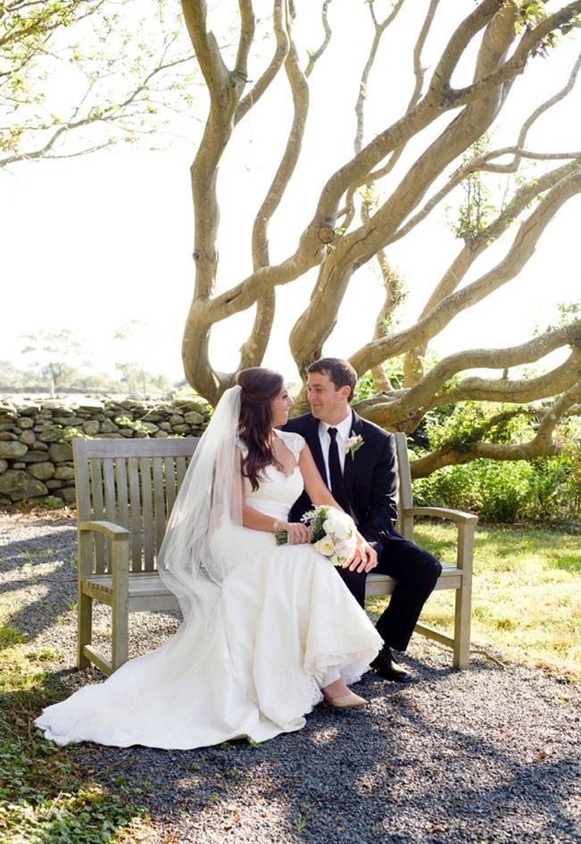 bride and groom sitting under a tree