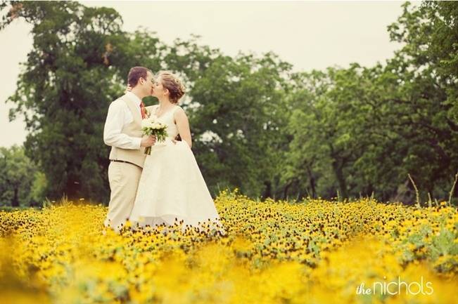 bride and groom in field of yellow flowers