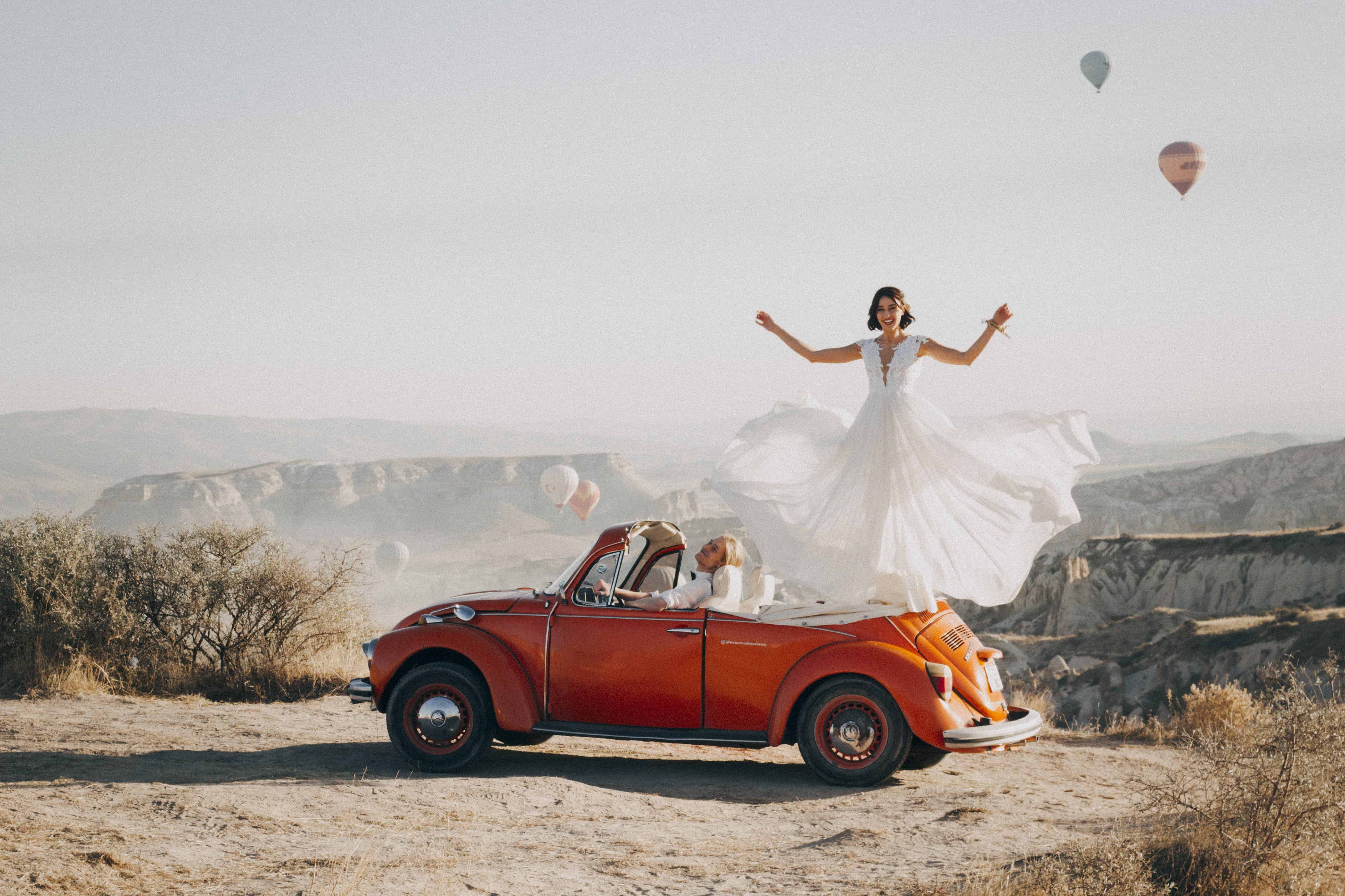 Woman Standing on Volkswagen Beetle