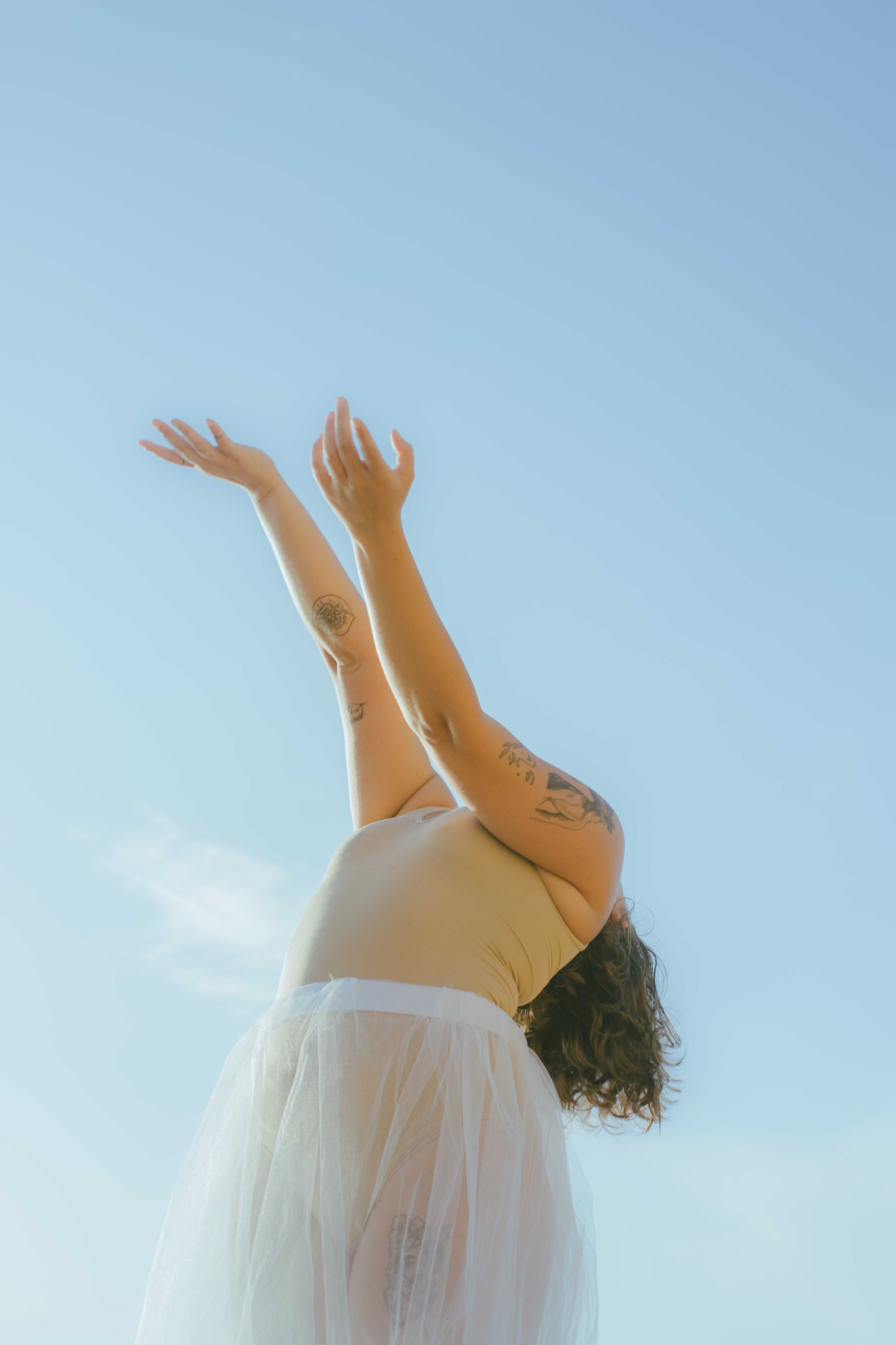 Free Woman in White Dress Raising Her Hands Stock Photo