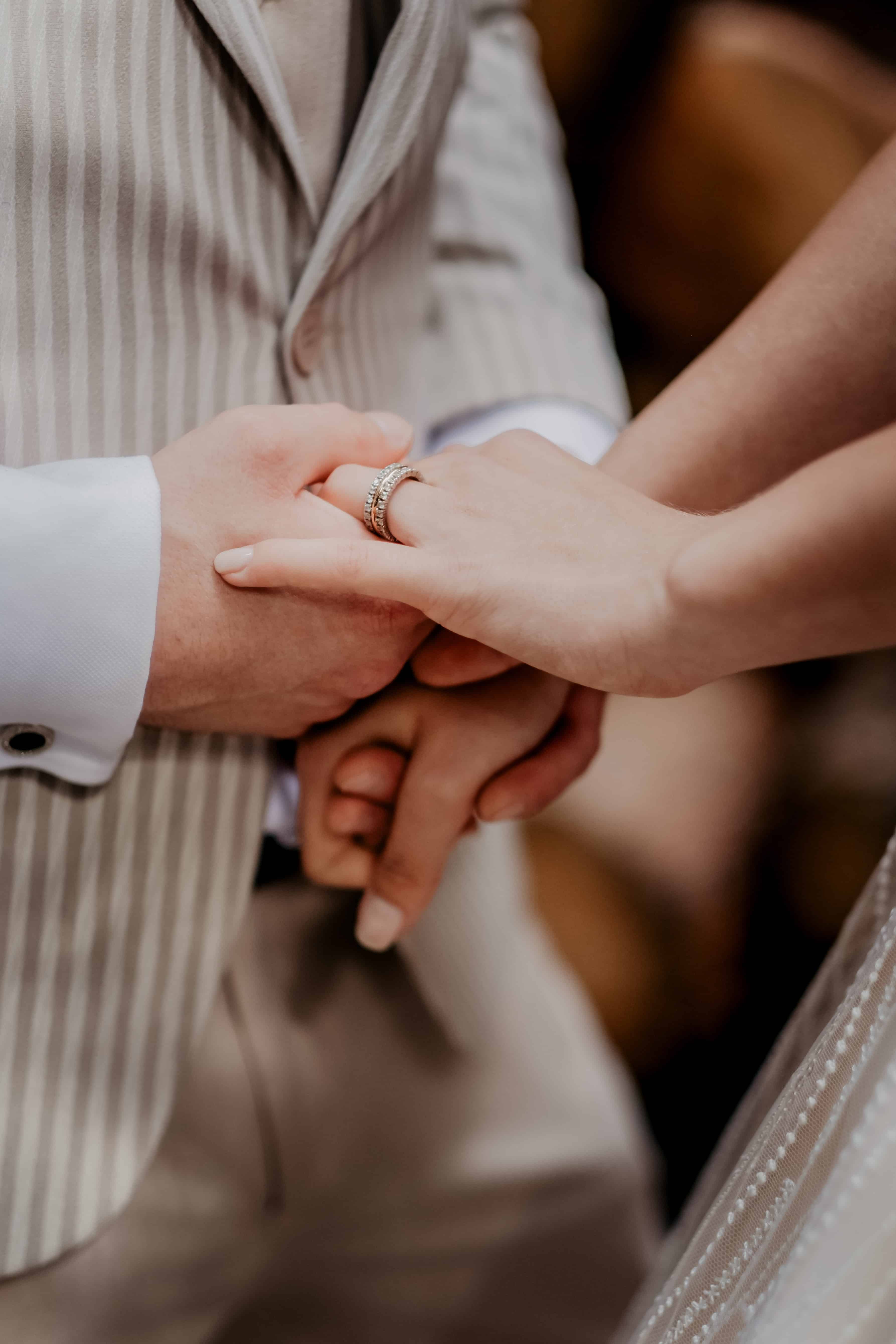 man in white dress shirt holding womans hand