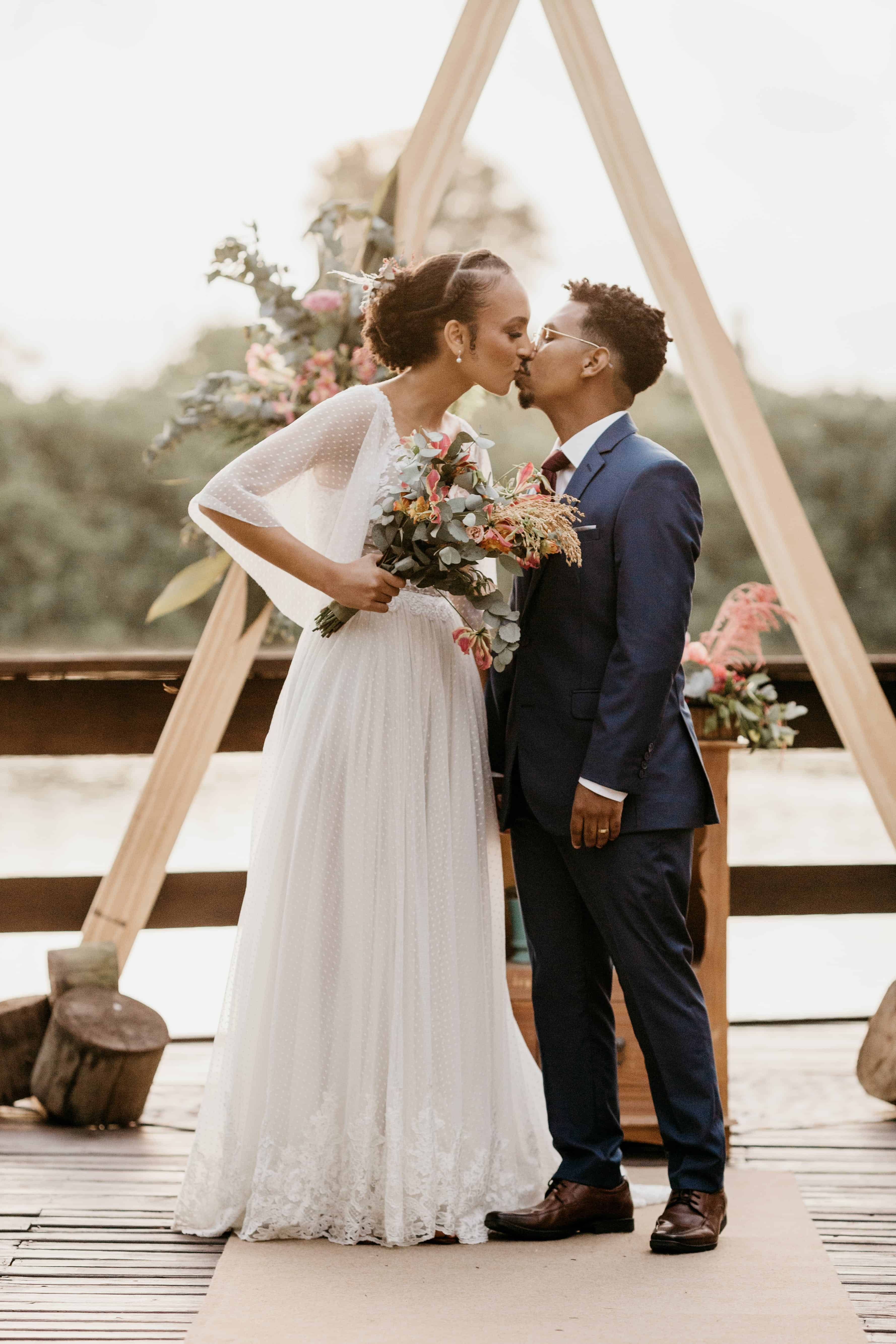 Free Diverse newlywed couple kissing on wooden terrace Stock Photo