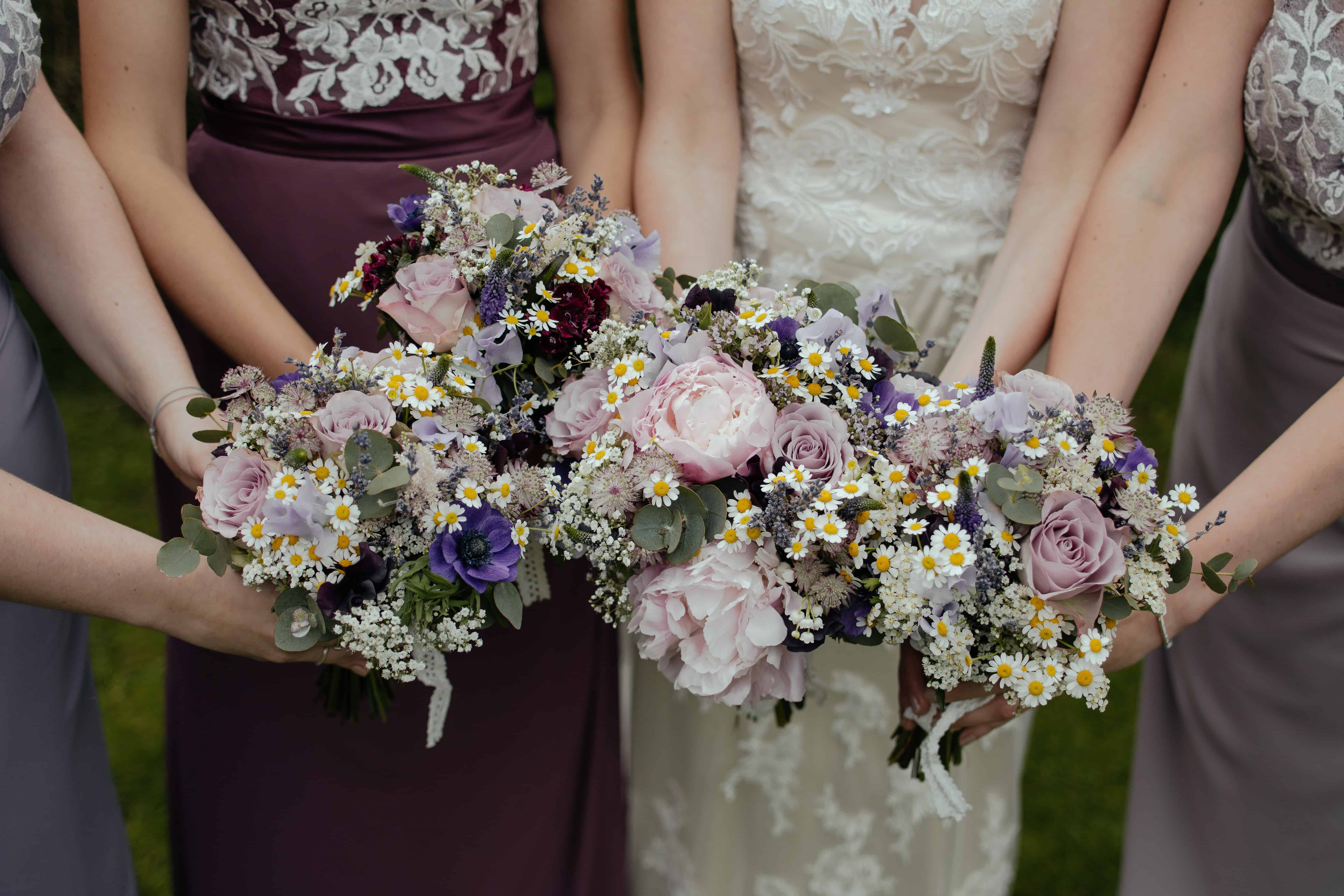 four women carrying bouquet of flowers